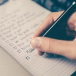 A hand taking notes with a fancy pen